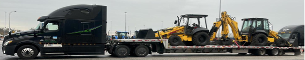 Black truck with drop deck trailer hauling heavy equipment shipping