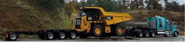 Blue trailer with a removable gooseneck hauling heavy equipment shipping