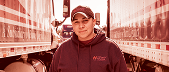 One person standing next to a truck, smiling for the camera.