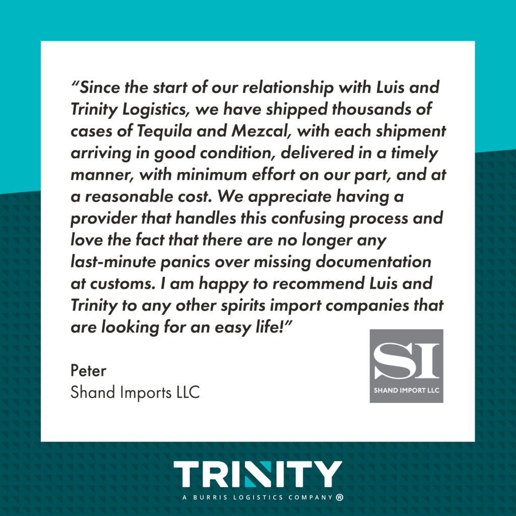 A graphic of a Trinity customer testimonial of their cross border shipping services. The testimonial reads, "Since the start of our relationship with Luis and Trinity Logistics, we have shipped thousands of cases of Tequila and Mezcal, with each shipment arriving in good condition, delivered in a timely manner, with minimum effort on our part, and at a reasonable cost. We appreciate having a provider that handles this confusing process and love the fact that there are no longer any last-minute panics over missing documentation at customs. I am happy to recommend Luis and Trinity to any other spirits import companies that are looking for an easy life!" The testimonial is attributed to Peter at Shand Imports LLC. Their logo, which features a large white SI surrounded by a gray rectangle, is featured underneath the testimonial. The testimonial is black text with a white background. Behind the testimonial background is a teal background. 