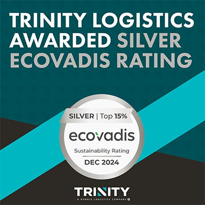 A graphic that reads "Trinity Logistics Awarded Silver EcoVadis Rating." This is in all caps and the "Trinity Logistics Awarded" is in white while the "Silver EcoVadis Rating" is in a silver-gray color. Below that is the Silver EcoVadis badge. It is a white circle with a silver border. There is a silver banner across the top that reads "Silver Top 15%" in black. Below that is the EcoVadis logo in black. Below that it reads in smaller black text "Sustainability Rating - DEC 2024". Below the EcoVadis logo is the Trinity Logistics logo. In the background is a mix of diagonals with the Trinity brand colors - black, teal, and a dark teal. 