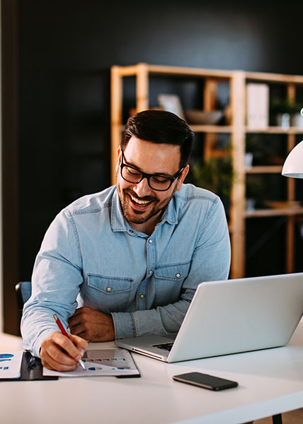 Young business man working at home with laptop and papers on desk