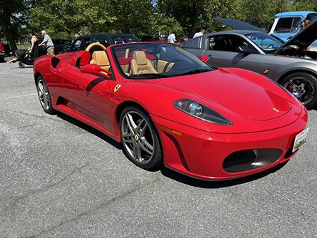 Red classic sports car on display at an automotive event highlighting specialty auto transportation needs.